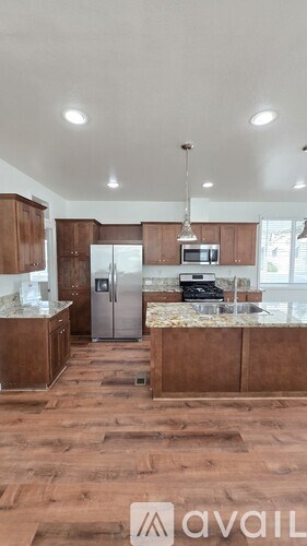A kitchen with wooden floors and a countertop with a microwave and toaster oven.