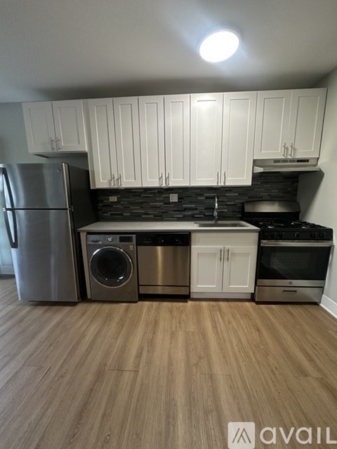 A kitchen with wooden floors and white cabinets.