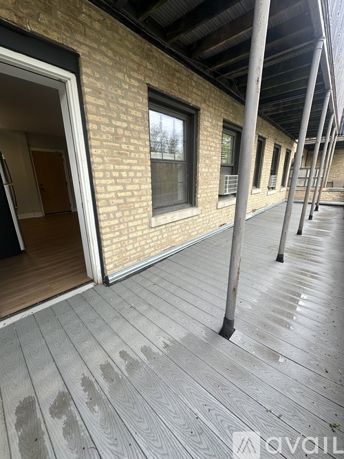 A long wooden deck with a brick building in the background.
