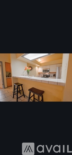 A kitchen with a bar stool and a counter.