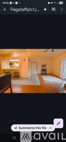 A room with a wooden floor and a rug in the center.