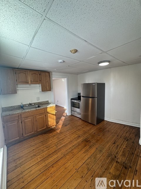 A kitchen with wooden cabinets and a stainless steel refrigerator.
