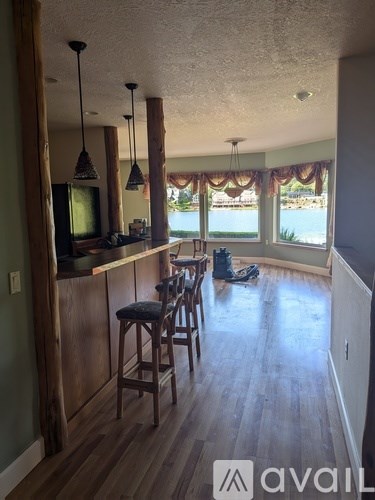 A kitchen with a bar area and a television.
