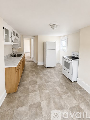 A kitchen with white appliances and wooden cabinets.