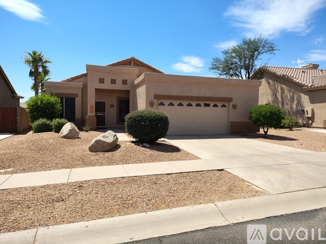 A house with a driveway and a palm tree in front.