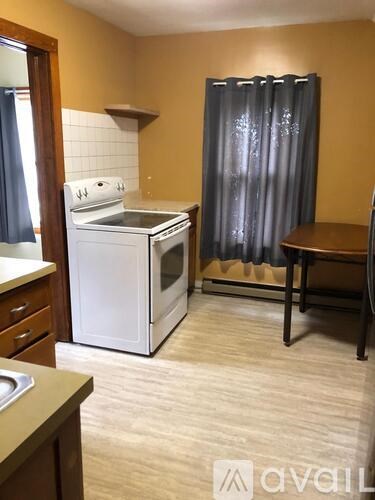 A small kitchen with a white oven and a table.