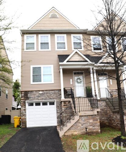 A two-story house with a garage and a driveway.