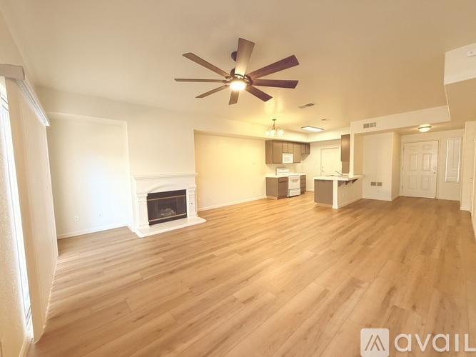 A spacious room with a fireplace and wooden flooring.