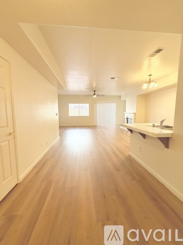 A long hallway with wooden floors and white walls.