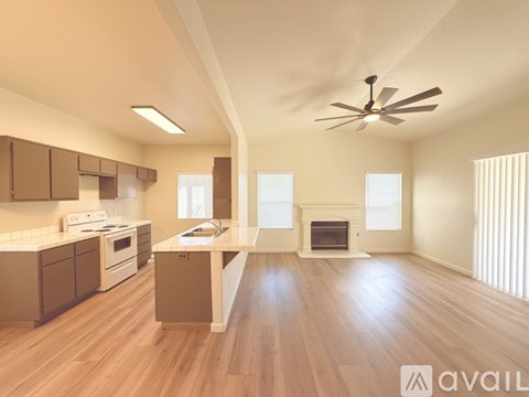 A spacious kitchen and living room with wooden floors and a fireplace.