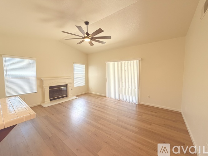 A room with a fireplace and a ceiling fan.