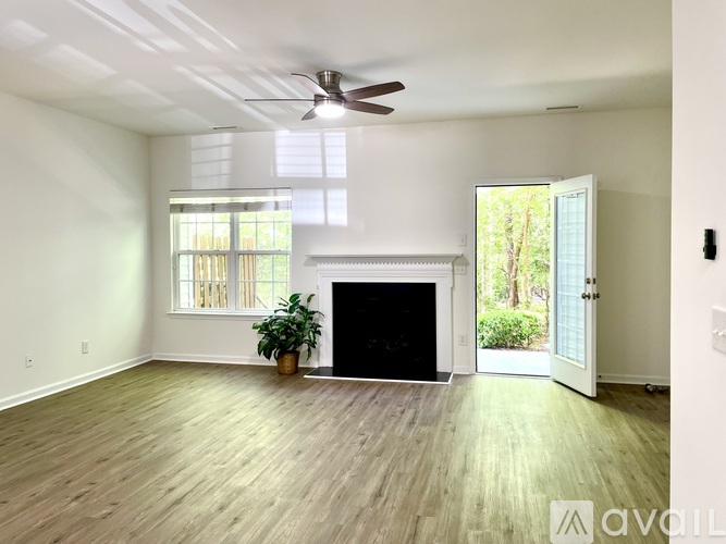 A living room with a fireplace and a ceiling fan.