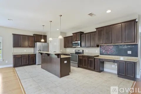 A kitchen with dark brown cabinets and a large island.