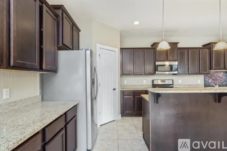 A kitchen with brown cabinets and a granite countertop.
