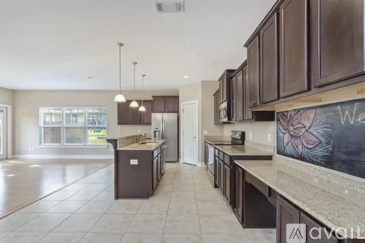A kitchen with brown cabinets and a chalkboard wall.