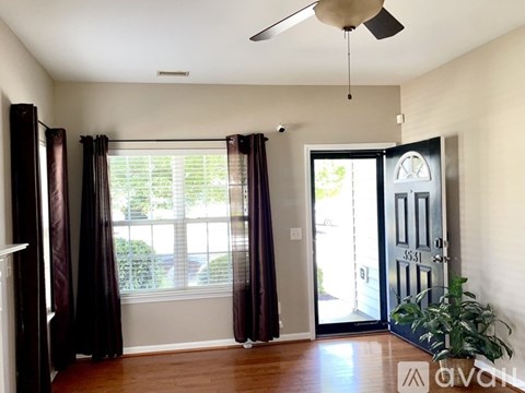 A room with a ceiling fan, sliding glass doors, and a plant.