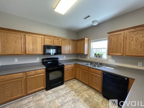 A kitchen with wooden cabinets and black appliances.