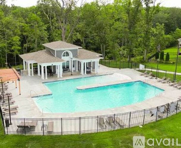 A pool with a pavilion in the background.