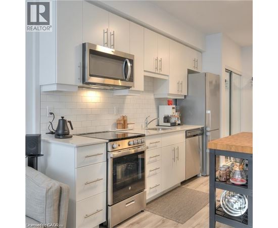 A modern kitchen with white cabinets and stainless steel appliances.