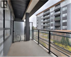 A balcony with a glass railing and a view of a building across the way.
