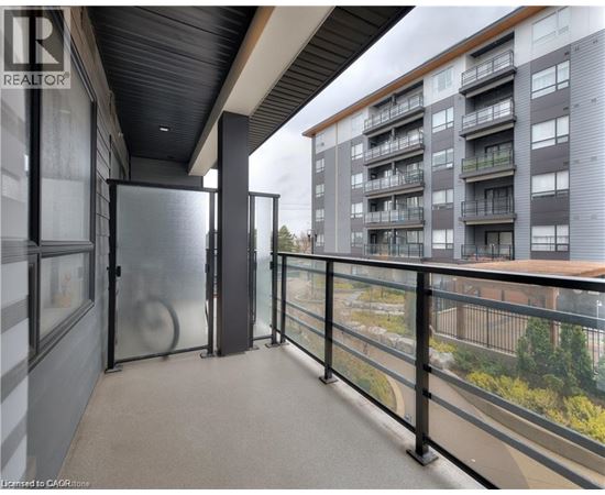 A balcony with a glass railing and a view of a building across the way.