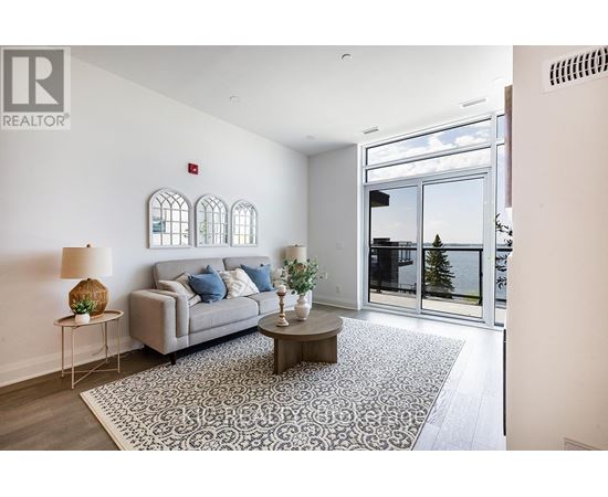A living room with a grey couch, a coffee table, and a rug.