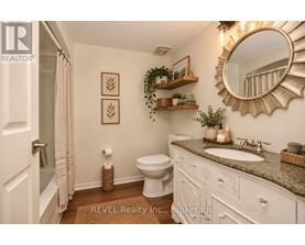 A bathroom with a toilet, sink, and mirror.