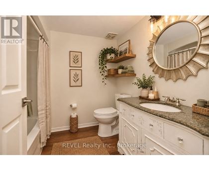 A bathroom with a toilet, sink, and mirror.