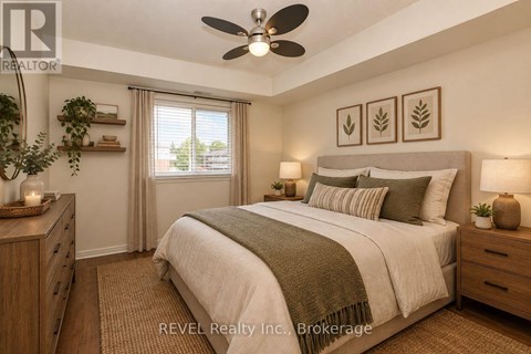 A bedroom with a large bed, a ceiling fan, and a window with curtains.
