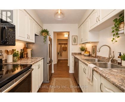 A kitchen with white cabinets and a black microwave.