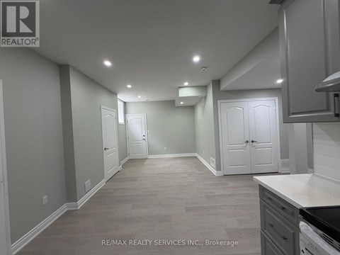 A spacious kitchen and dining area with white cabinets and a grey floor.