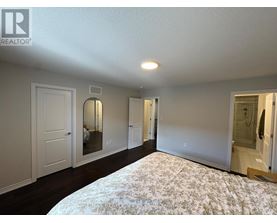 A bedroom with a large bed and a mirror on the wall.