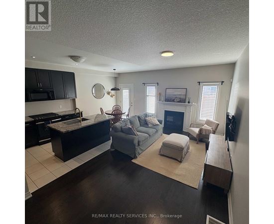 A living room with a grey couch and a fireplace.