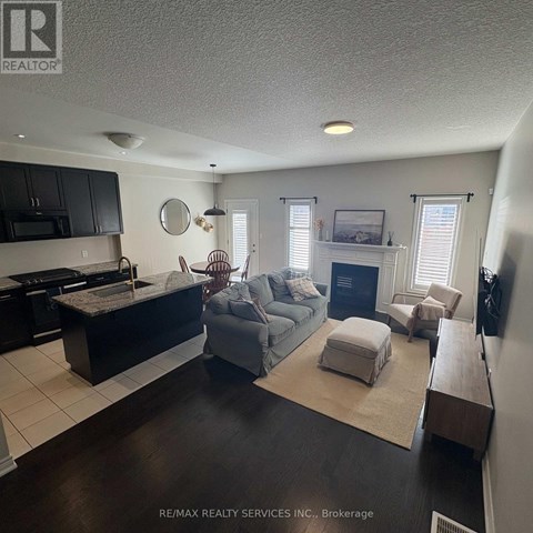 A living room with a grey couch and a fireplace.