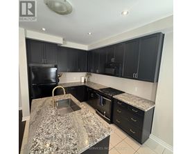 A kitchen with black cabinets and granite countertops.