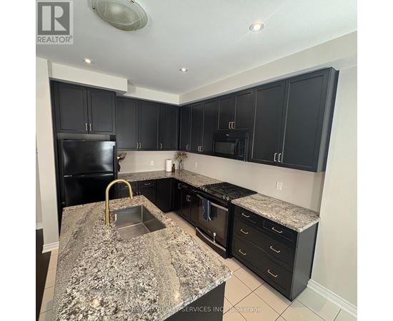 A kitchen with black cabinets and granite countertops.
