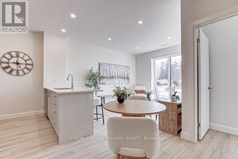 A well-lit kitchen with a dining table and chairs.
