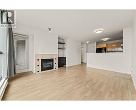 A spacious living room with a fireplace and wooden flooring.