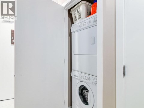 A white washing machine is in a small laundry room.