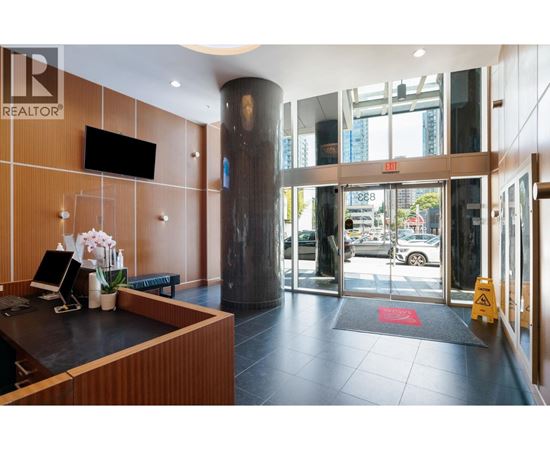 A reception area with a wooden wall and a black counter.