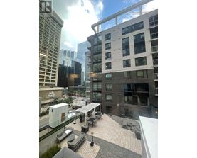 A view of a cityscape with apartment buildings and a cloudy sky.