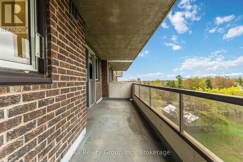 A balcony of a building with a view of trees and a blue sky.