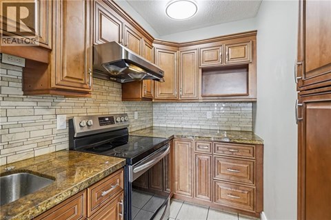 A kitchen with wooden cabinets and a black stove top oven.
