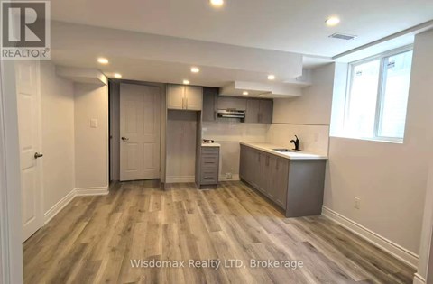 A kitchen area with wooden flooring and a countertop.