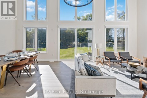 A well-lit living room with a dining table and chairs.