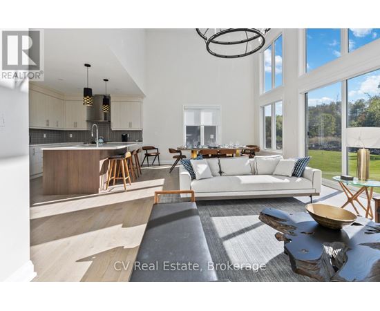 A modern living room with a kitchen area in the background.
