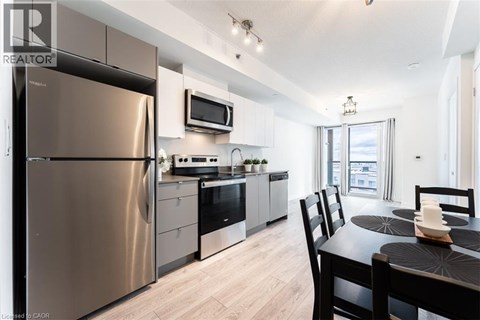 A modern kitchen with a stainless steel refrigerator and a dining table set for two.