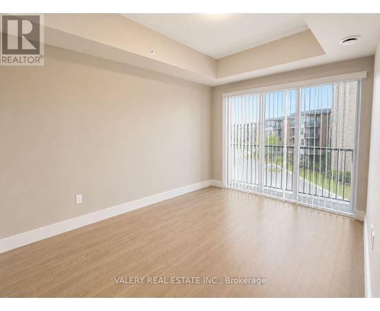 A spacious room with a sliding glass door leading to a balcony.