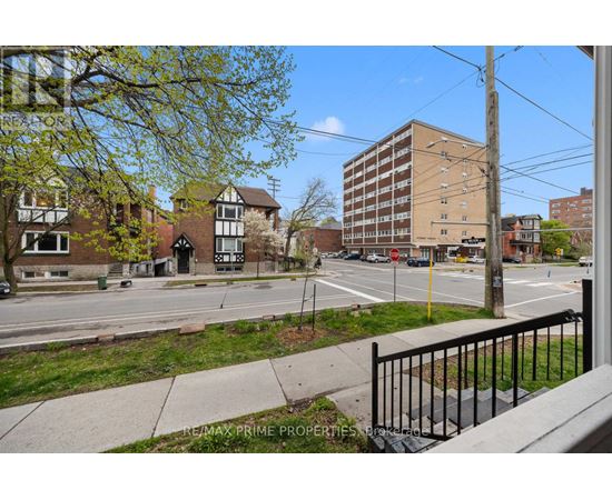 A street view with a building in the background and a sign that says REMAX PRIME PROPERTIES.