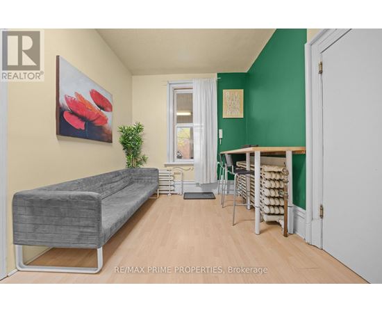 A living room with a grey couch and a green wall.